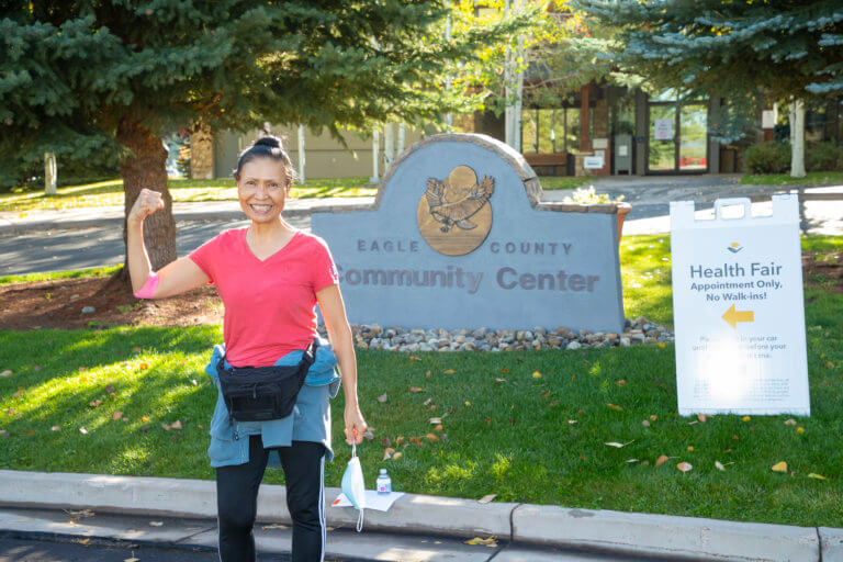 Woman flexing muscles outside the health fair