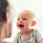 Newborn smiling at mom