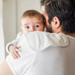 Father burping baby over shoulder