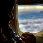 Mother breastfeeding baby on airplane