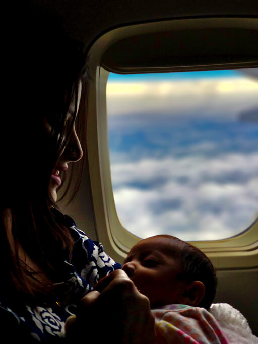 Mother breastfeeding baby on airplane