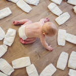 Baby surrounded by diapers