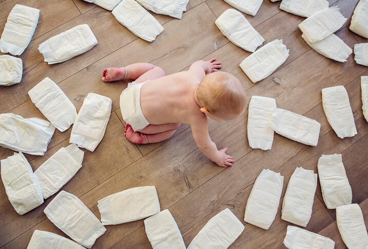 Baby surrounded by diapers