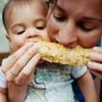 Mother and Baby sharing a corn on the cob