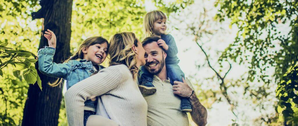 Young family outdoors smiling