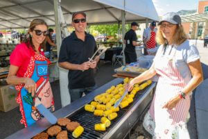 people grilling corn and burgers