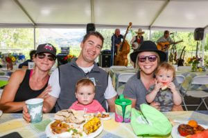 adults and children sitting at picnic table
