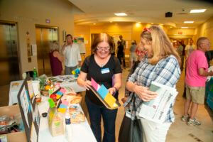 staff member showing education tool to women