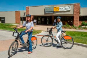 women on bikes in front of aspen valley hospital
