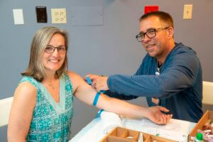 man applying tourniquet to woman's arm