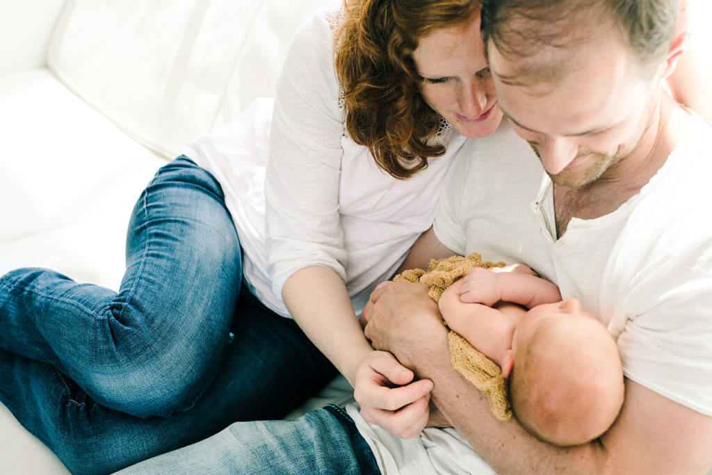 New parents holding newborn baby
