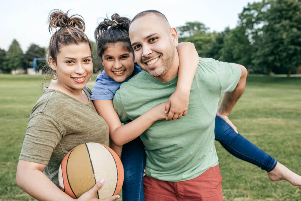 Family posing with basketball after a game