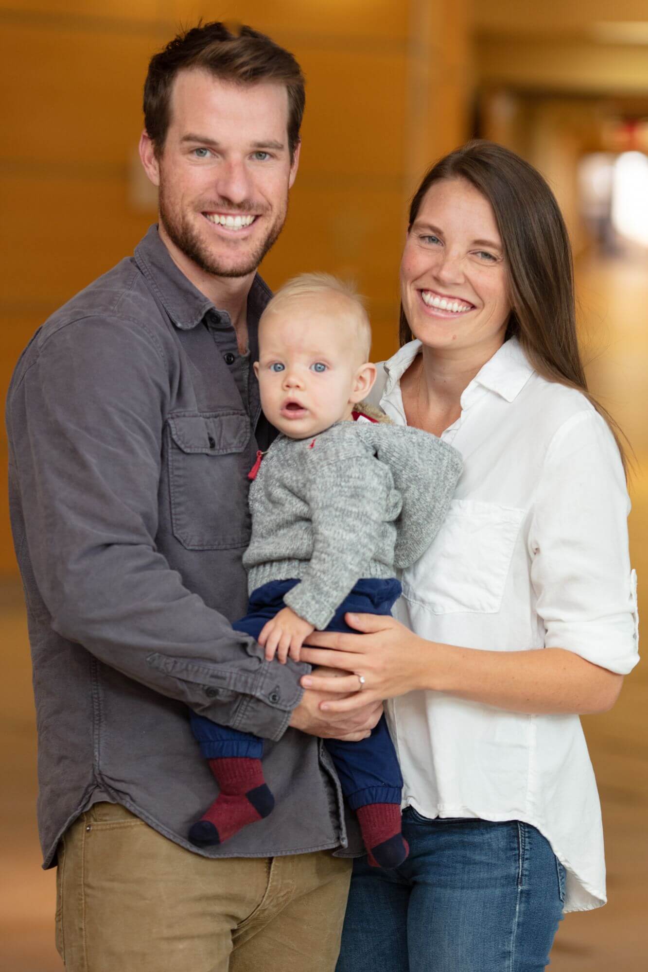 parents pose with their baby