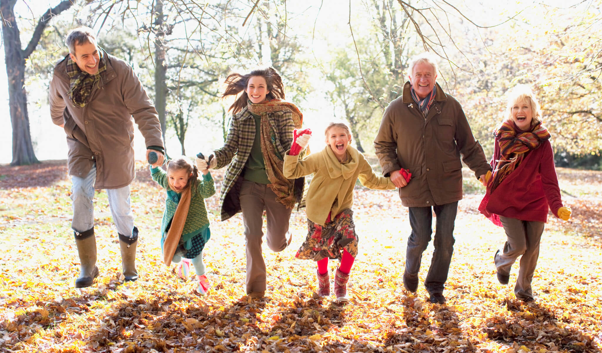 Family running in park in autumn