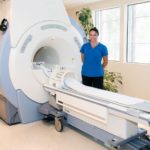 imaging tech standing next to machine