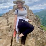 Middle-aged woman posing at mountain summit