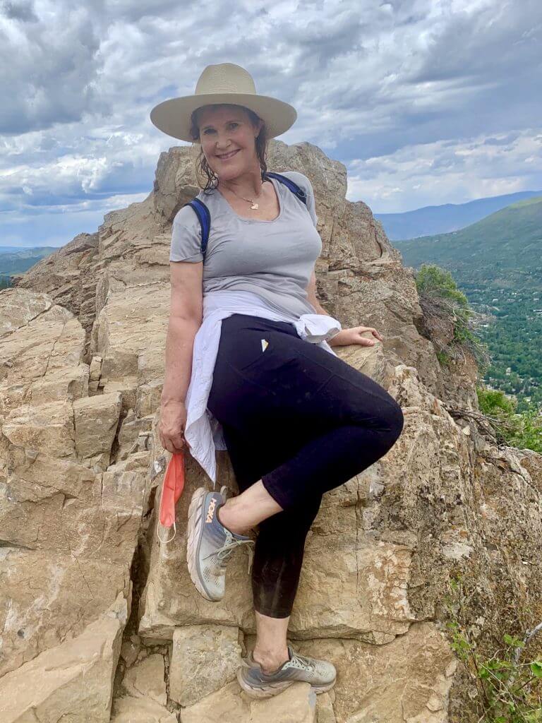 Middle-aged woman posing at mountain summit