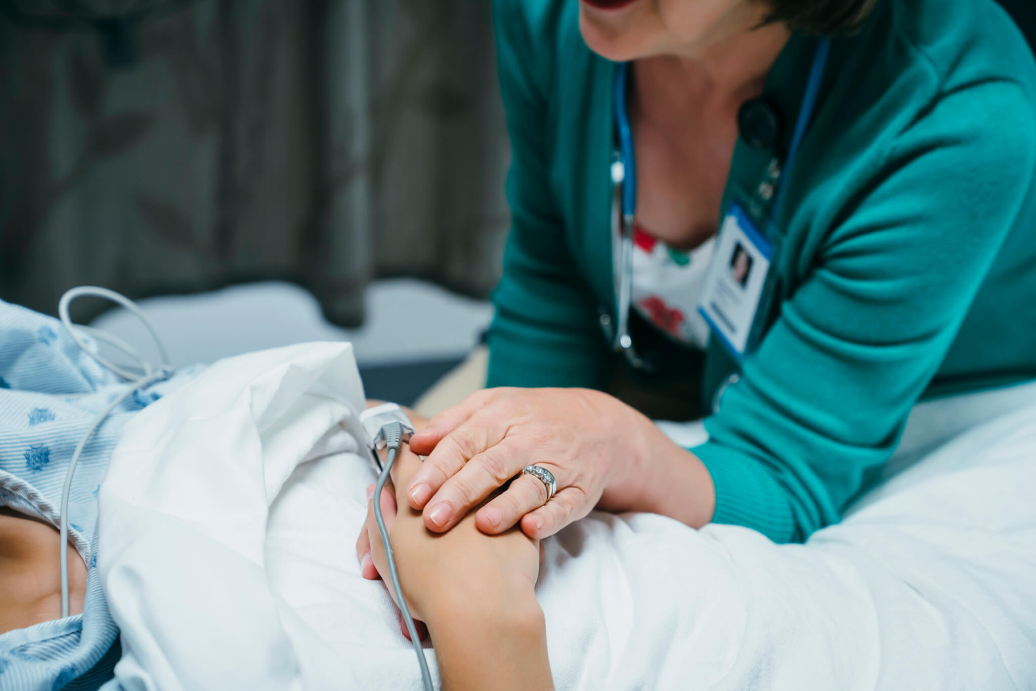 Doctor comforting patient in hospital bed