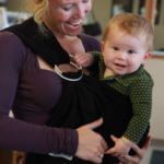 mother holding baby in bjorn