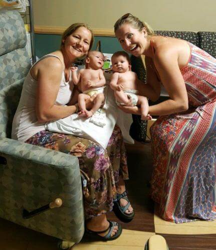 two women holding newborns next to each other