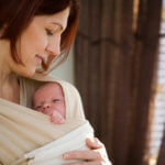 newborn baby held close to mother