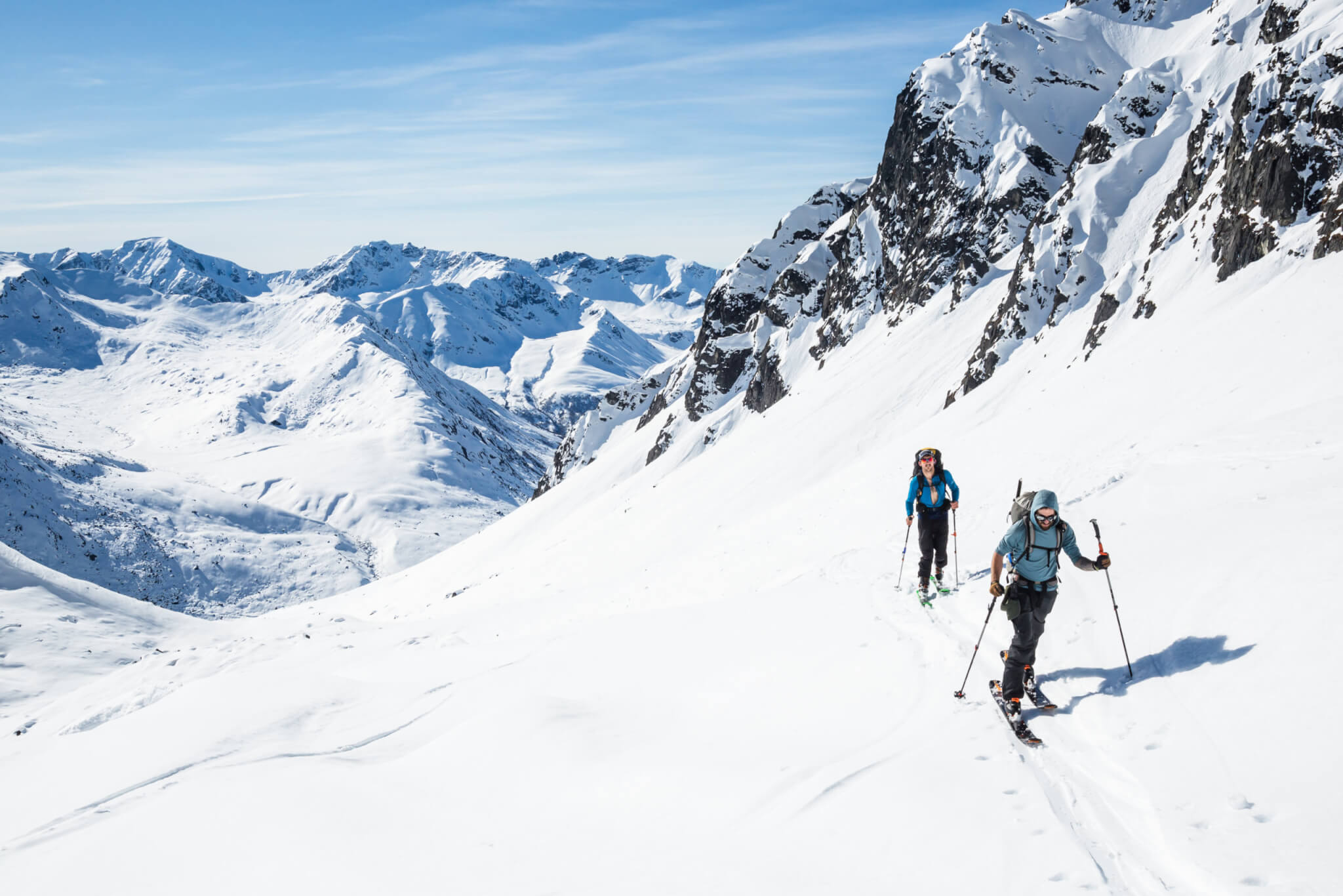 Skiers moving uphill on hot sunny day in the backcountry