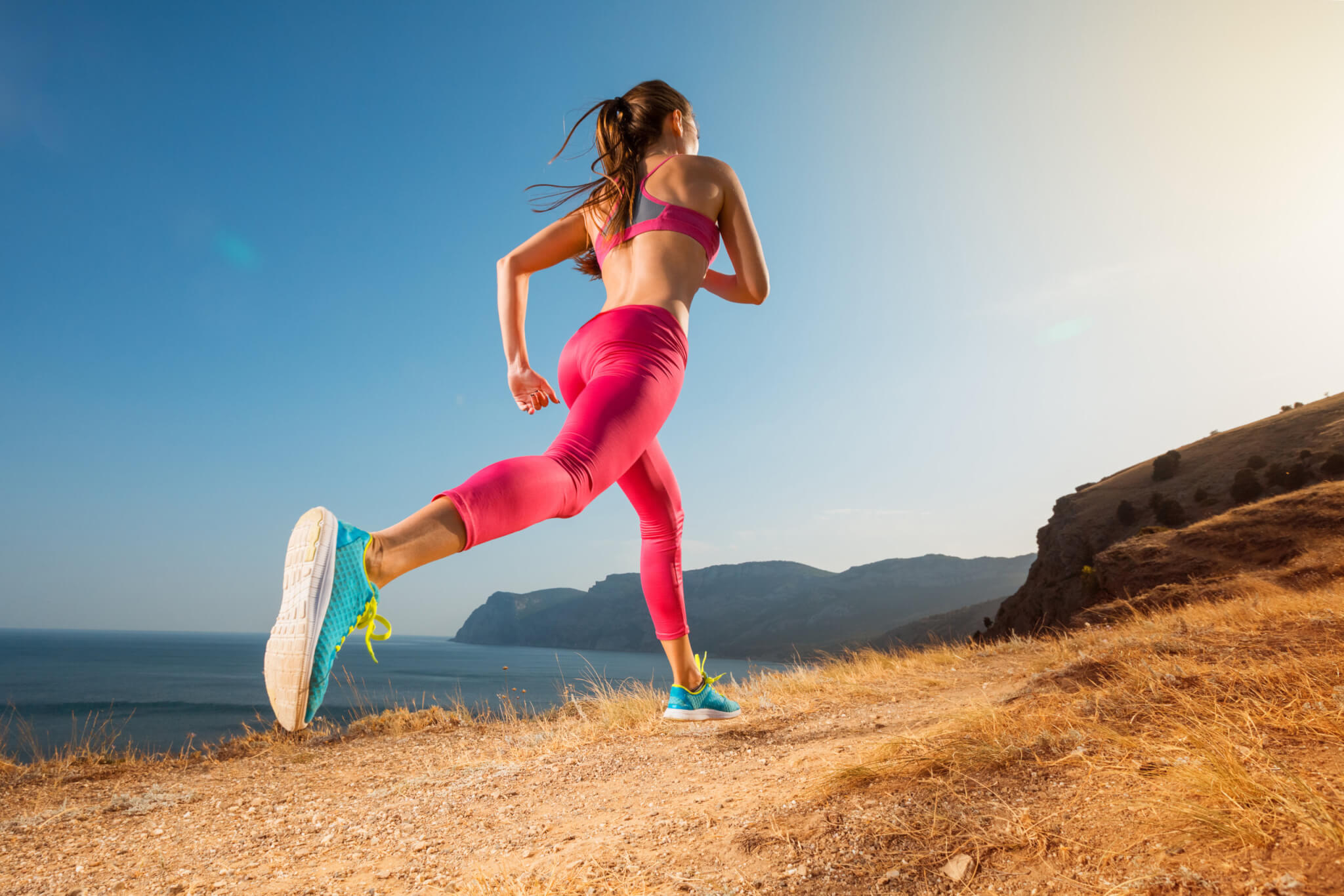Woman running up mountain trail