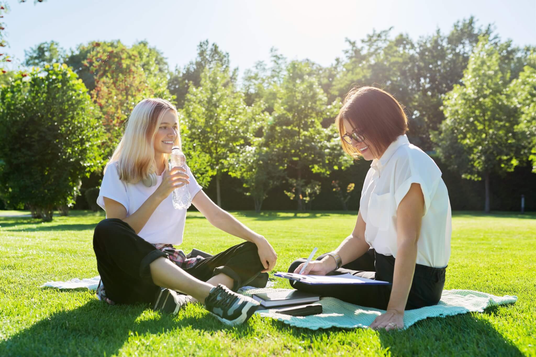 social worker speaking with teen student on lawn