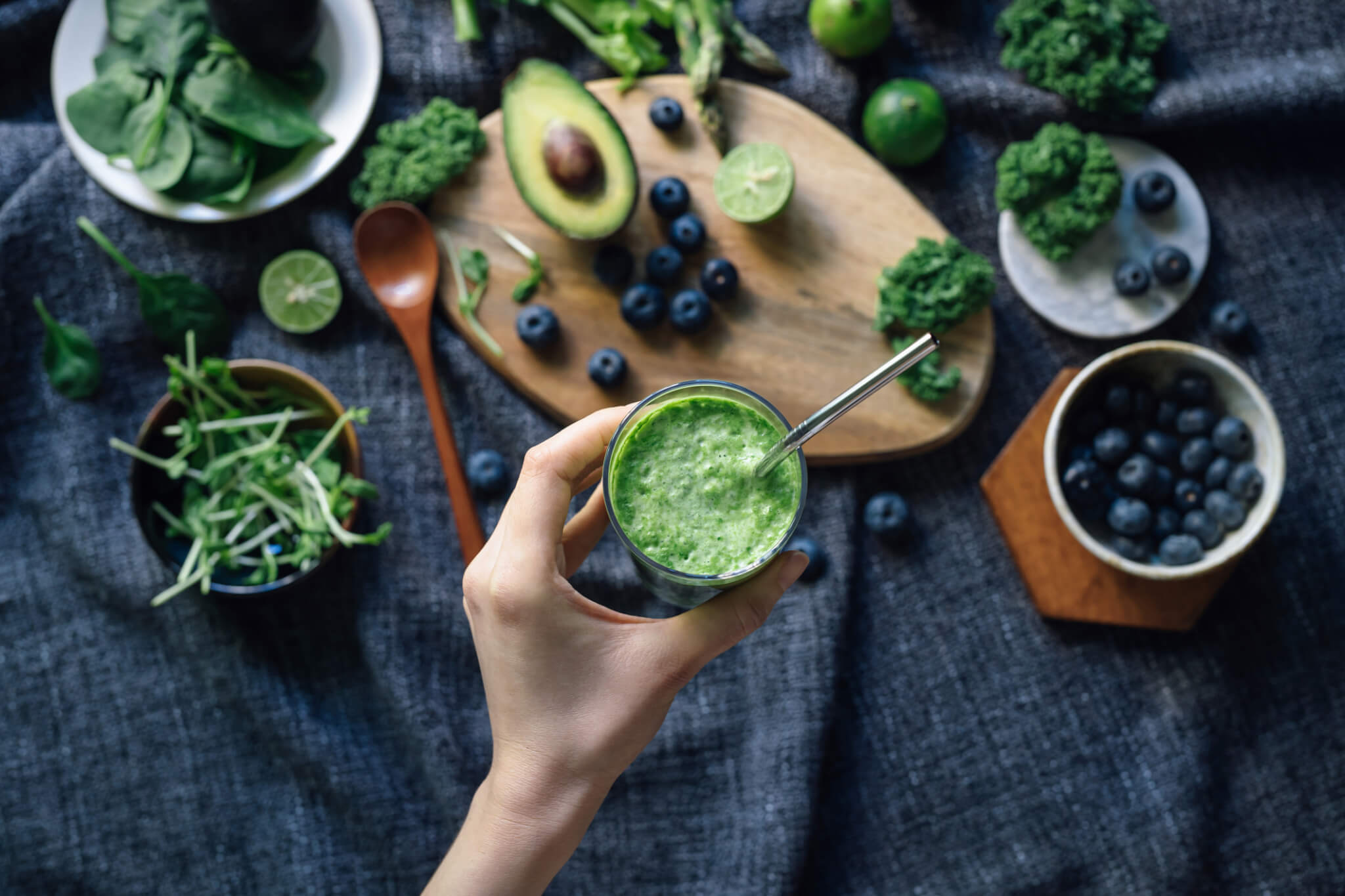 Flat lay of fresh and healthy green fruits and vegetables on a rustic wooden board
