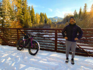 man standing on snowy bridge in mountains