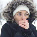 woman warms her hands in winter