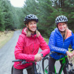 mother and daughter mountain biking on trail