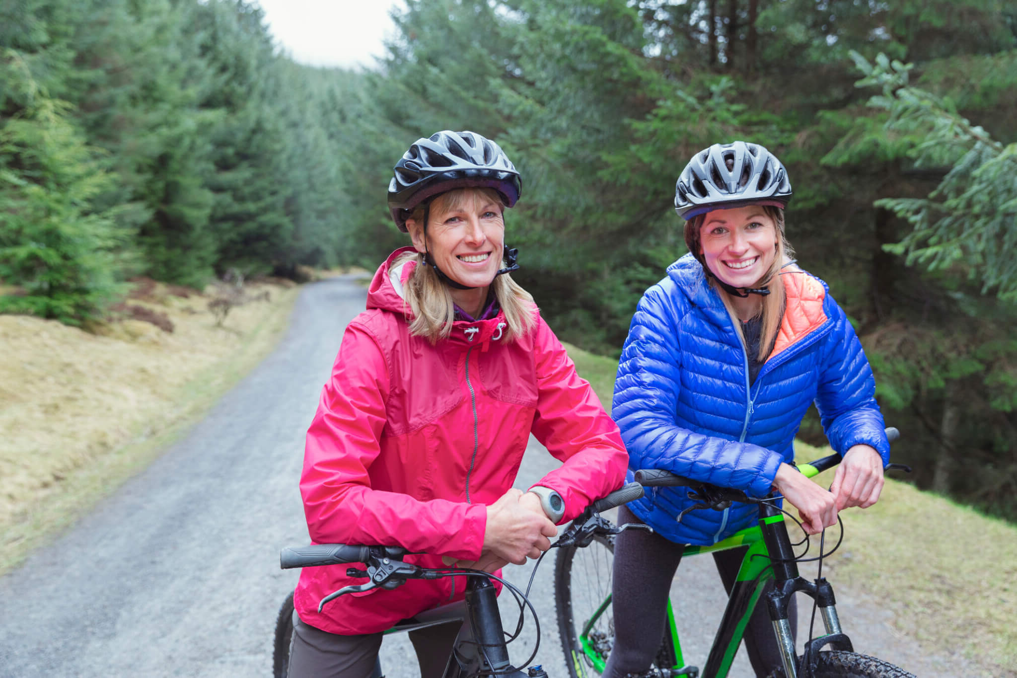 mother and daughter mountain biking on trail