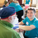Senior man receiving blood work at Health Fair
