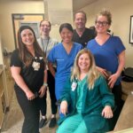 Group of nurses smiling at reception desk area