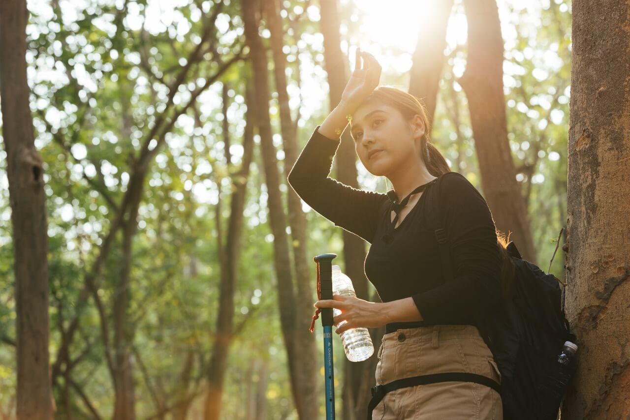 Young woman feeling exhausted during the trekking - how to prevent heat exhaustion
