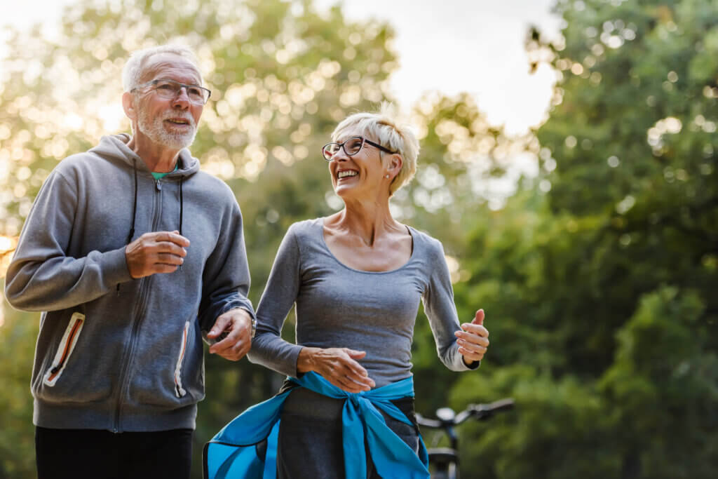 Smiling senior couple jogging in the park - how to prevent sarcopenia
