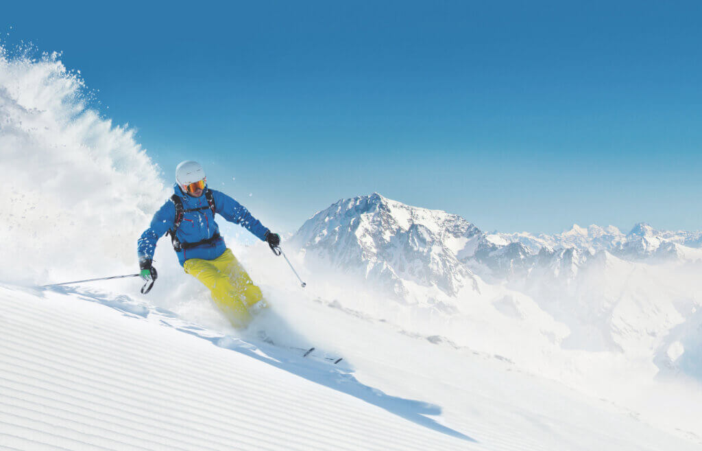 Man skier running downhill on sunny alpine slope