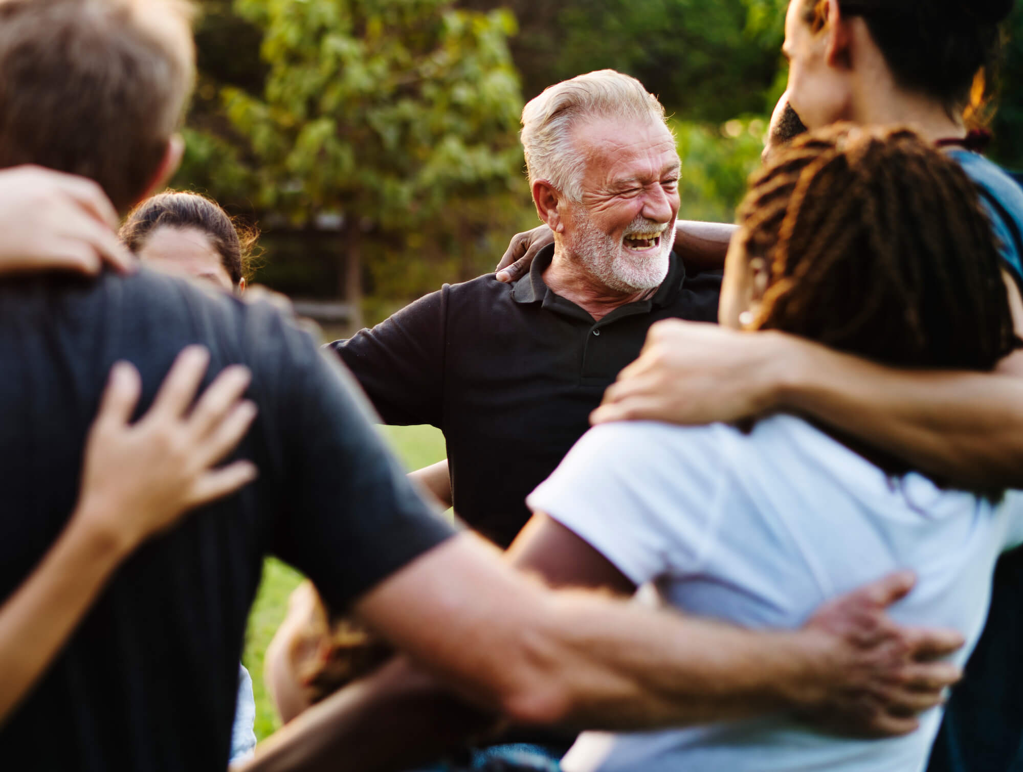 Group of people huddle and smiling together show the benefits of donating blood