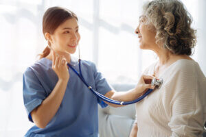 doctor measure heart rate by stethoscope on older patient. 