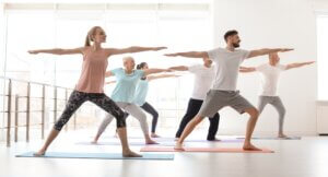 Group of people in sportswear practicing yoga indoors
