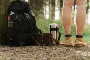 Forest hike - Female legs and hiker's backpack on the ground guide to hiking injuries
