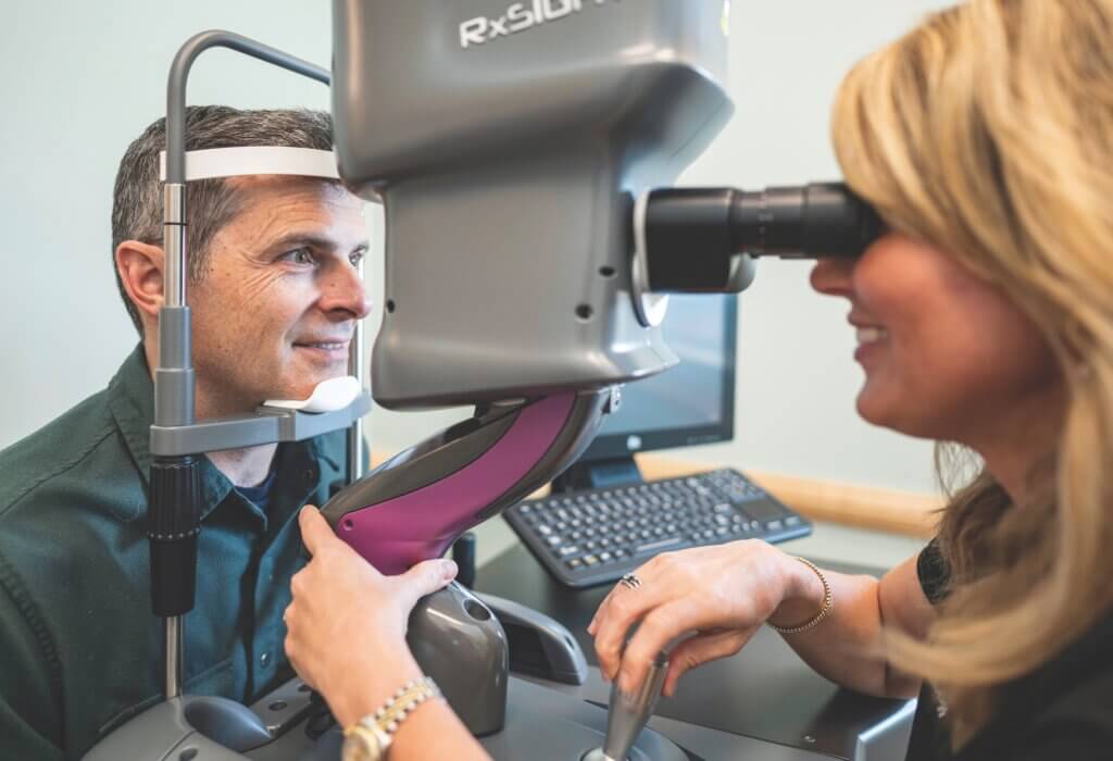 dr chance sanders inspecting a patient's eyes with light adjustable lenses