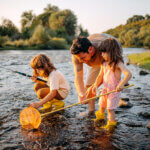 Father with two kids collects pebbles savoring summer and living well