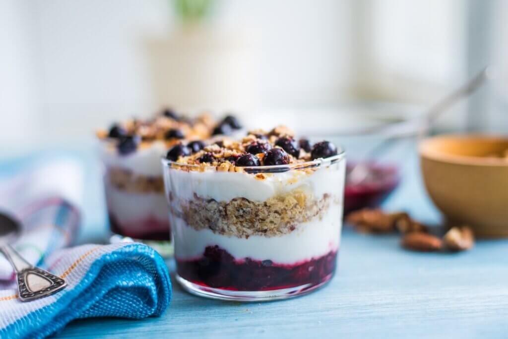 Delicious dessert - yogurt parfait with jam, nuts and currants in a glass healthy meals holiday leftovers