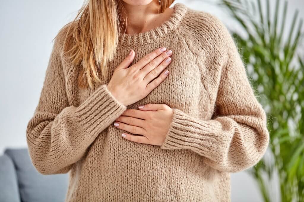 Young woman with heart problem holding chest. what is pots featured image
