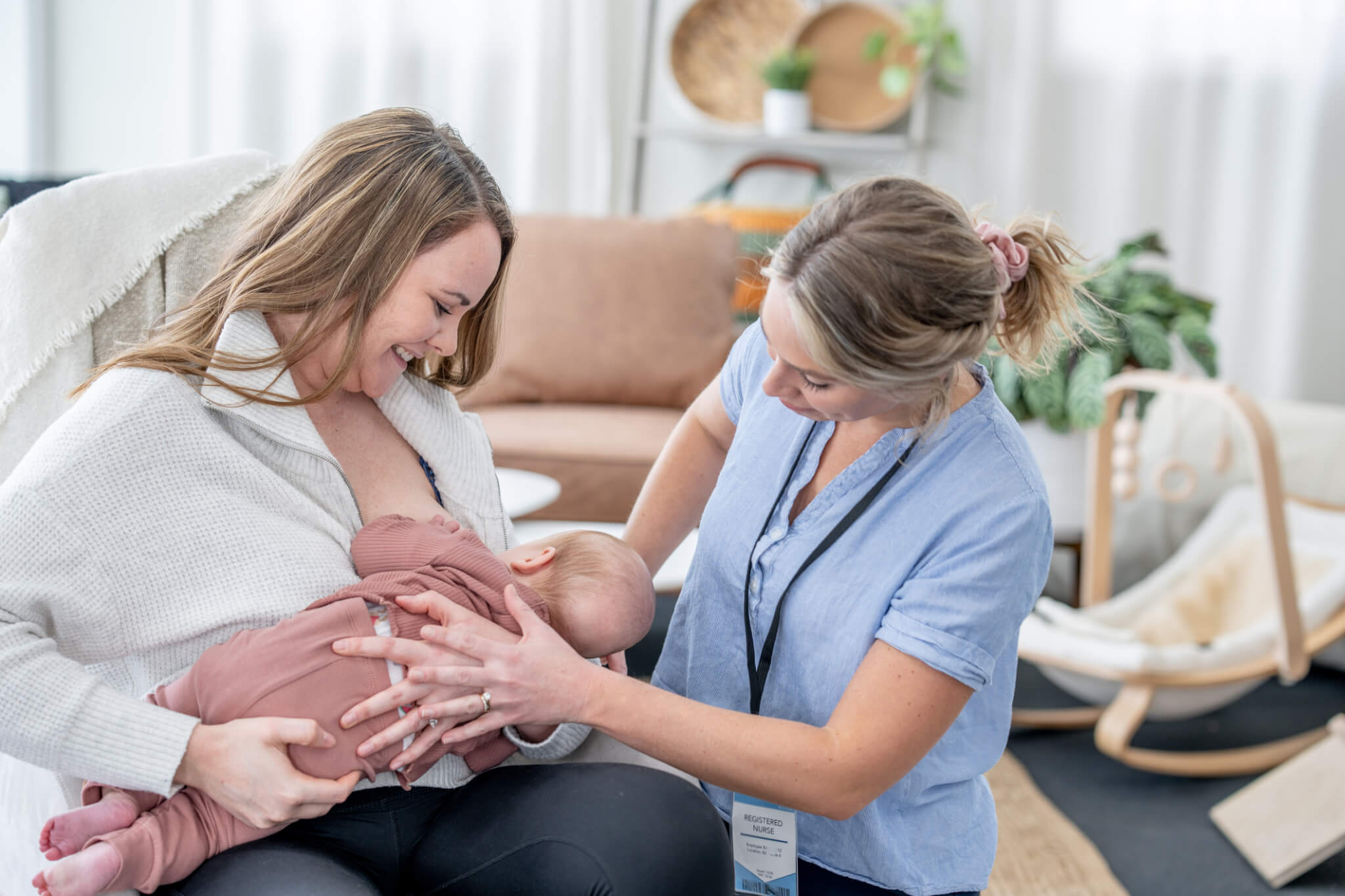 A new mother breastfeeds baby with the assistance of a Lactaction Consultant.