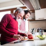 Hipster son with his senior father cooking in the kitchen. Two generations indoors. lifestyle choices for healthy heart