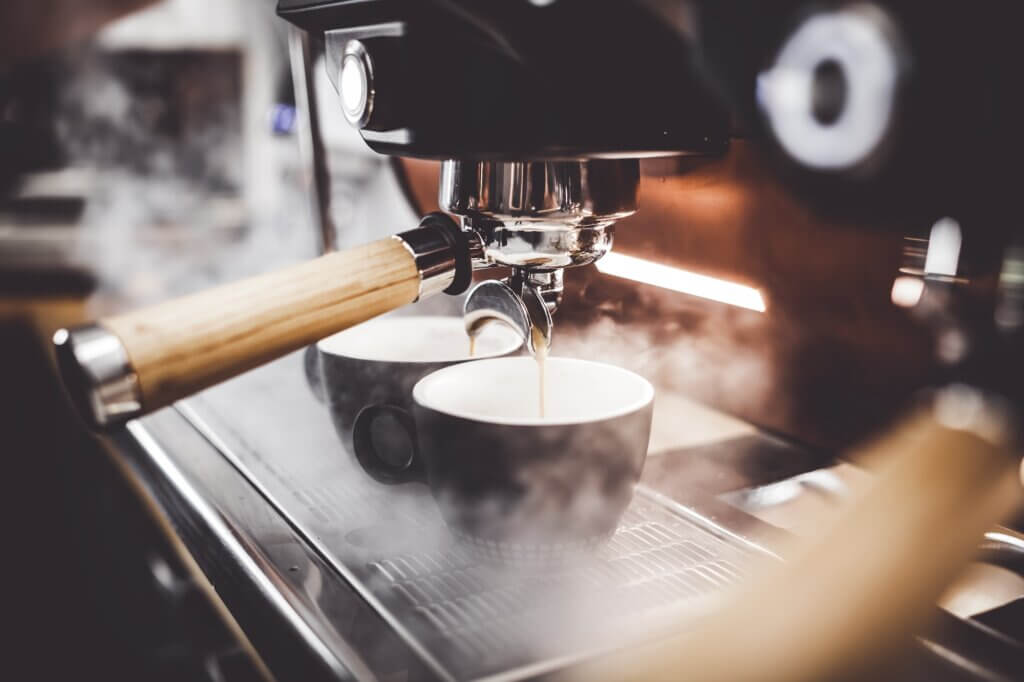 Espresso pouring from coffee machine at cafe