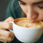 Close up girl is drinking coffee. how much caffeine per day